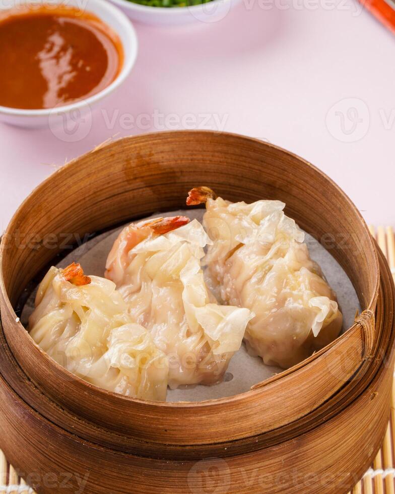 Assorted Chinese Dimsum in bamboo basket. Dimsum is a large range of small dishes that Cantonese people traditionally enjoy in restaurants for breakfast and lunch. photo
