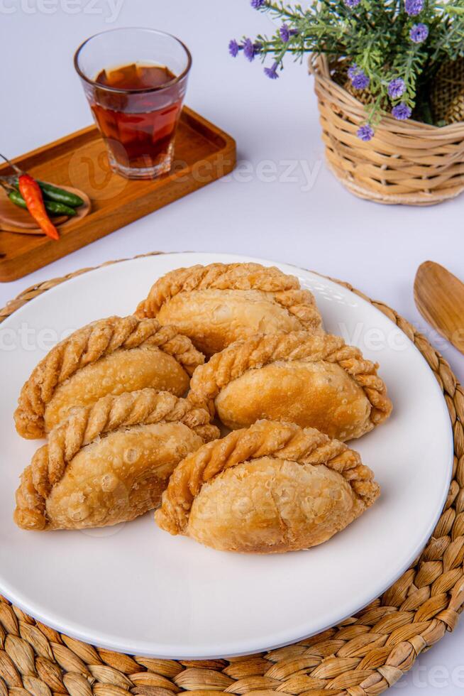 Curry puff or Pastel goreng. it is a small pie consisting of curry with chicken and potatoes in a deep fried or baked pastry shell photo