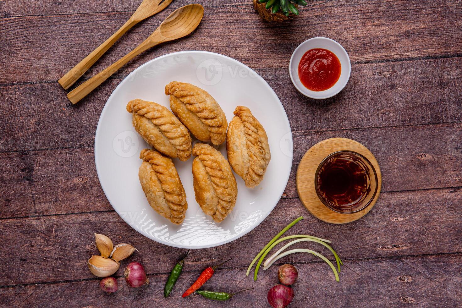 Curry puff or Pastel goreng. it is a small pie consisting of curry with chicken and potatoes in a deep fried or baked pastry shell photo
