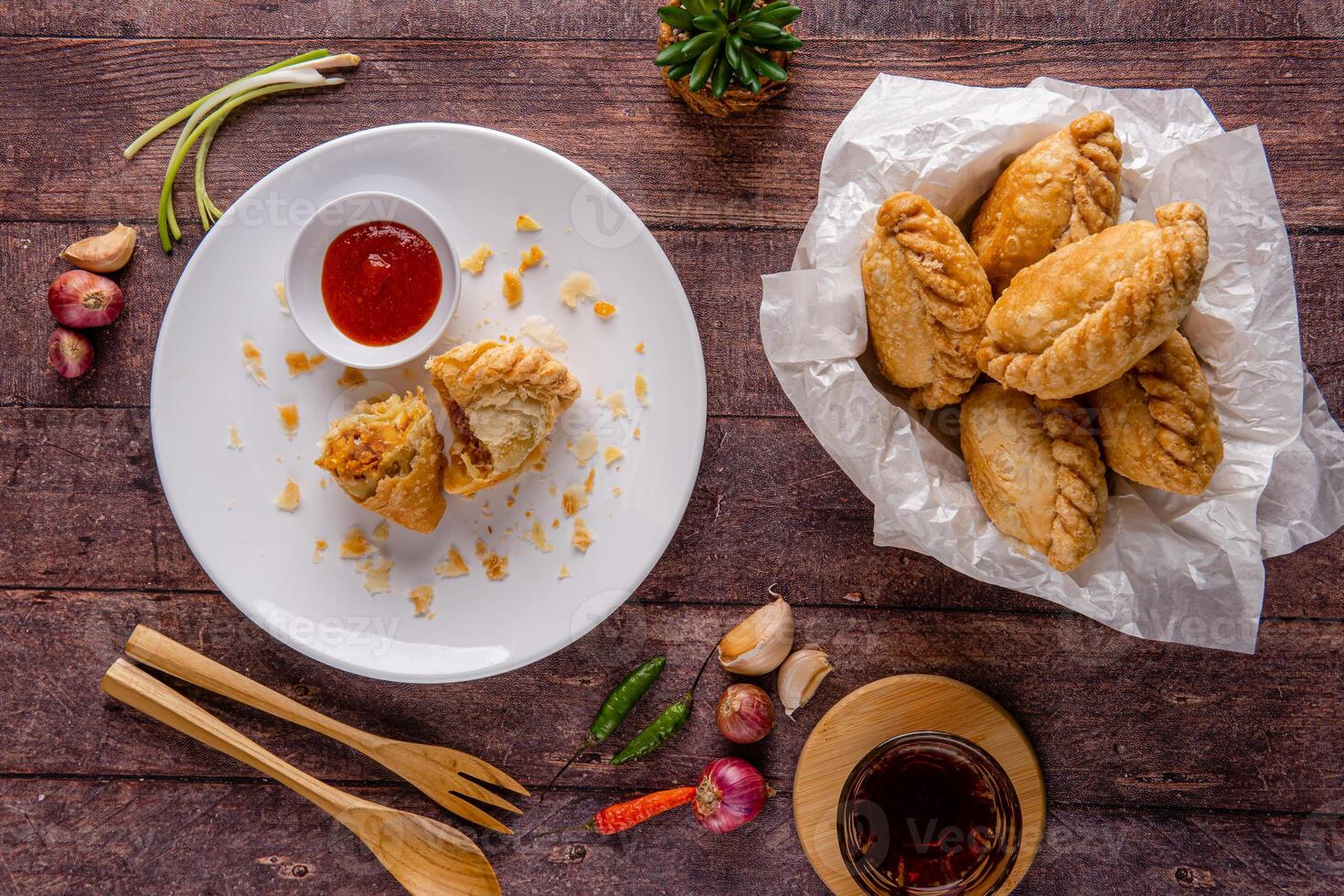 Curry puff or Pastel goreng. it is a small pie consisting of curry with chicken and potatoes in a deep fried or baked pastry shell photo