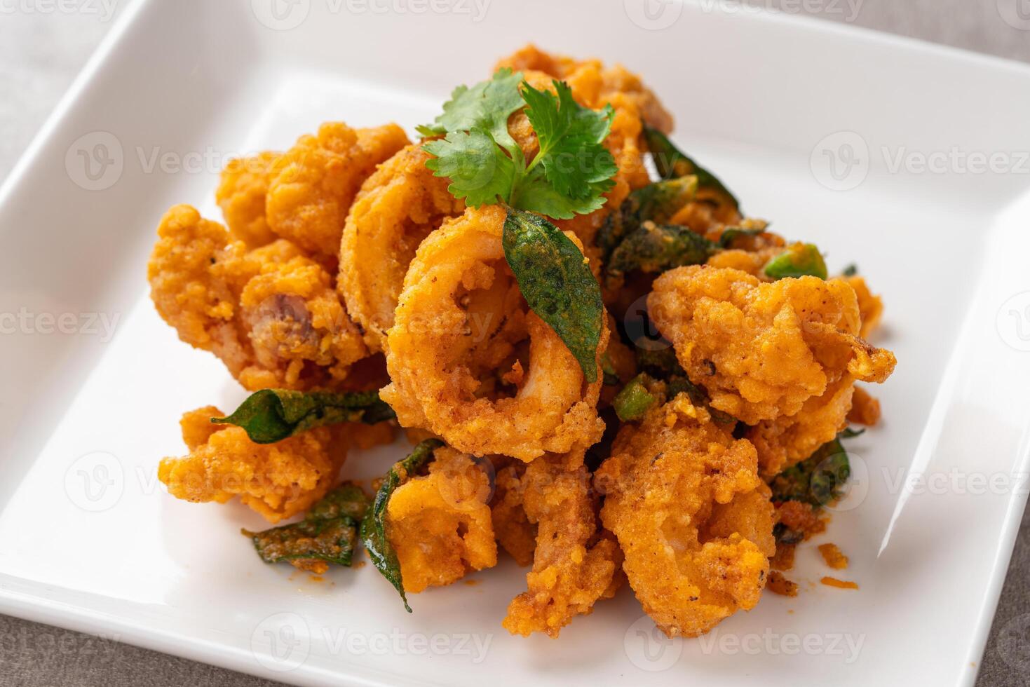 Stir Fried Squid with Salted Egg Yolk plating on white plate. photo