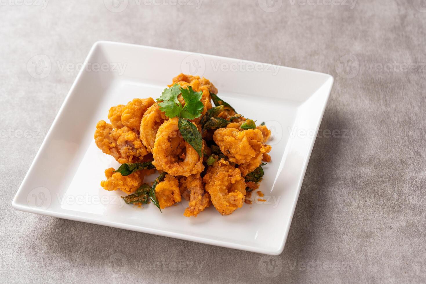 Stir Fried Squid with Salted Egg Yolk plating on white plate. photo