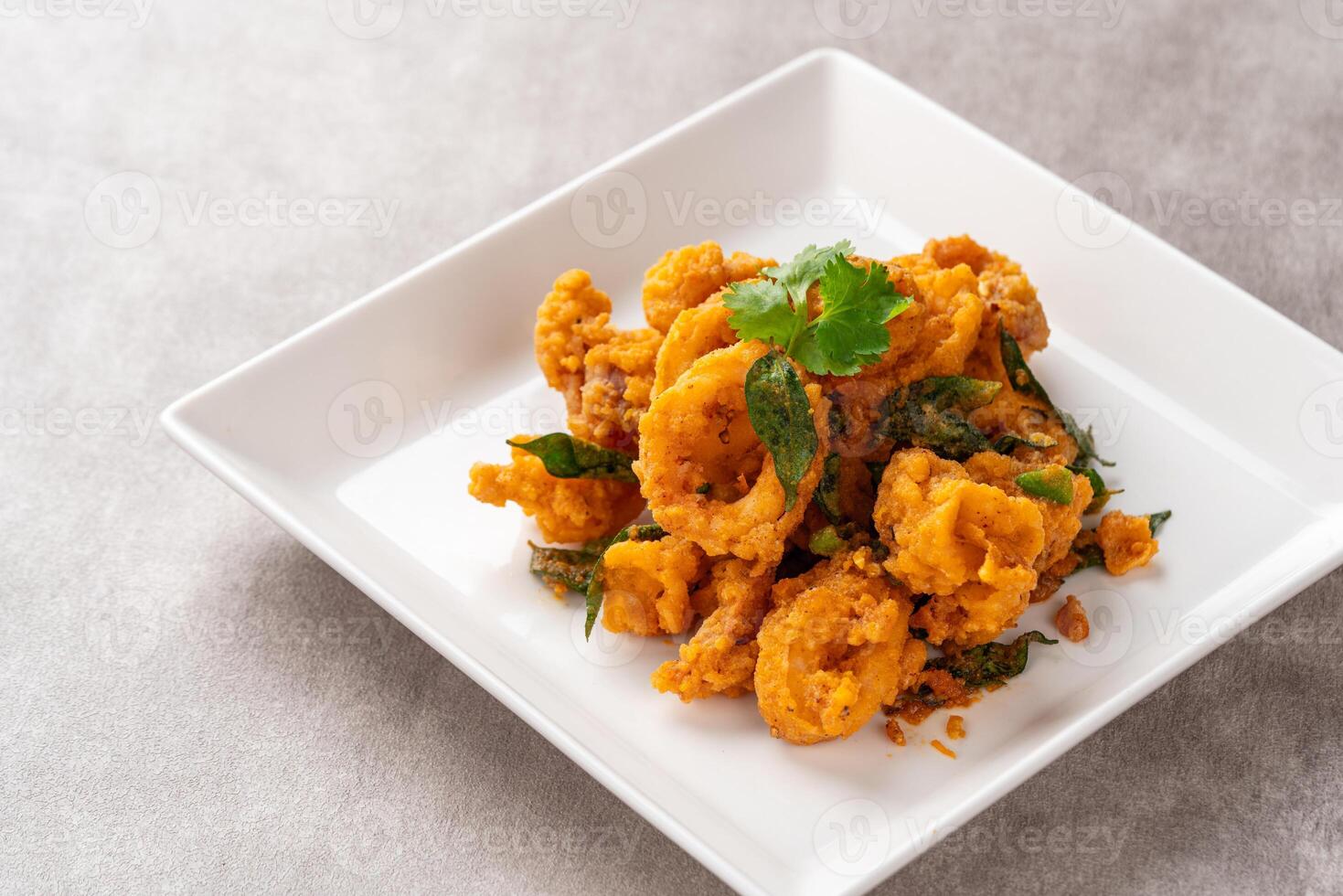 Stir Fried Squid with Salted Egg Yolk plating on white plate. photo