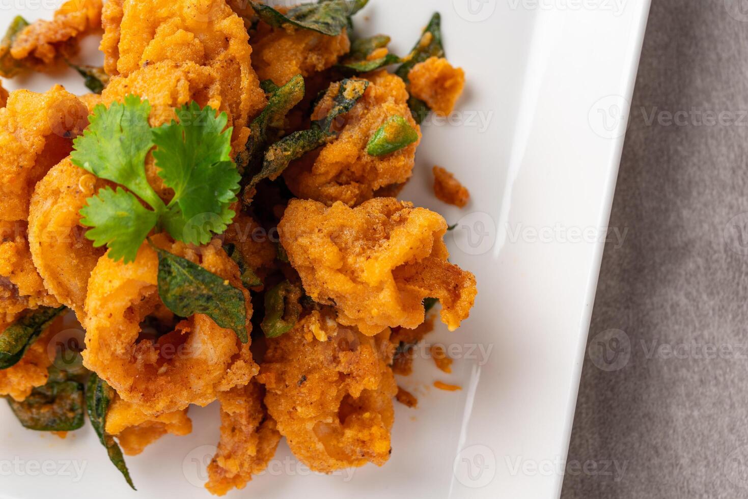 Stir Fried Squid with Salted Egg Yolk plating on white plate. photo