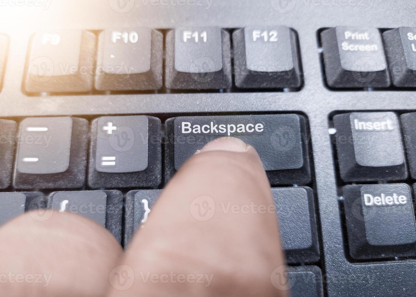 The finger push on the Backspace key on the keyboard, clear data computers concept. photo