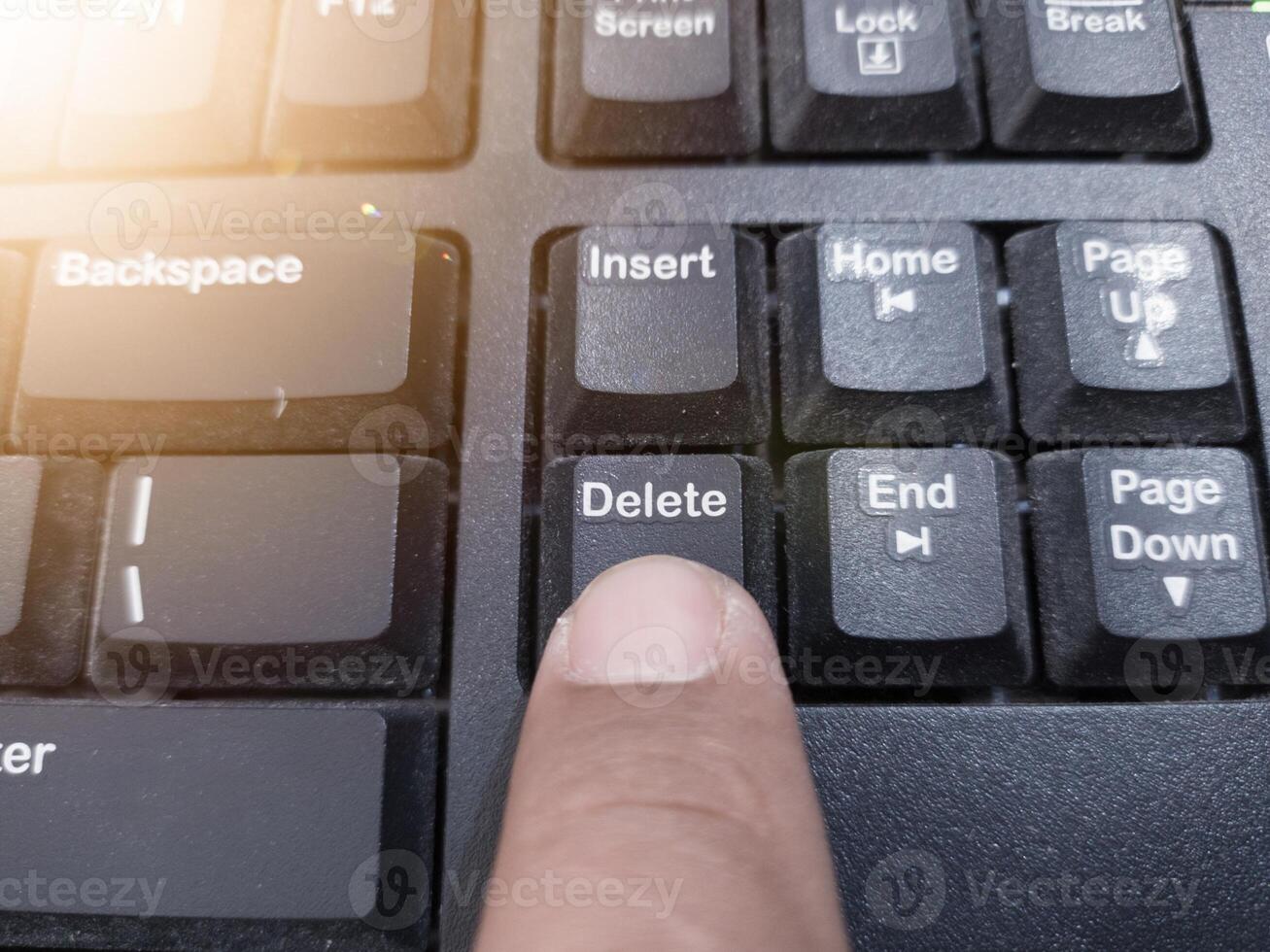 The finger push on the Delete key on the keyboard, clear data computer concept. photo