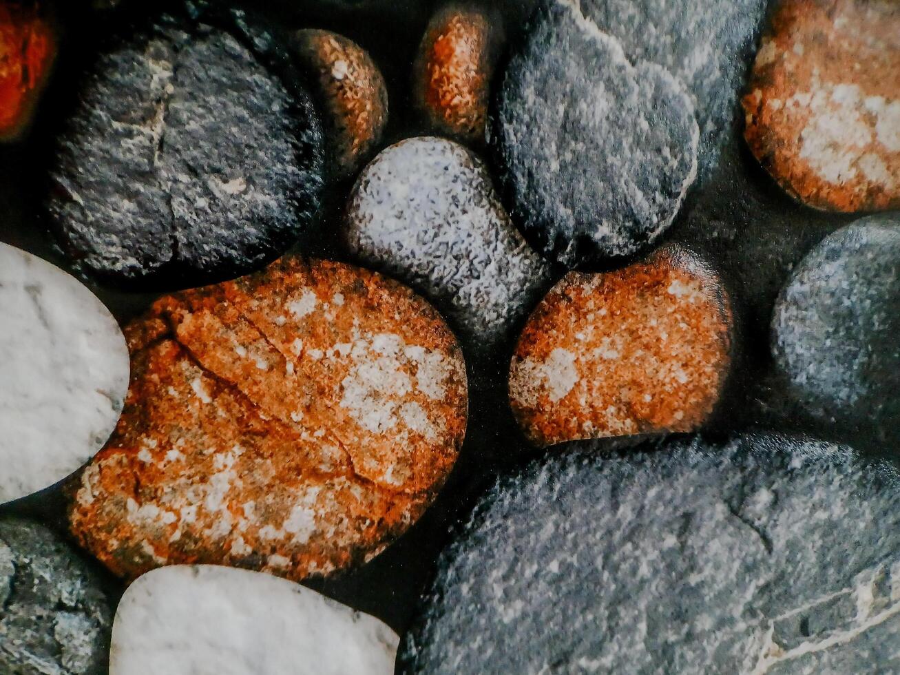 photo shows smooth, rounded stones arranged in a mosaic. The stones vary in color and texture.