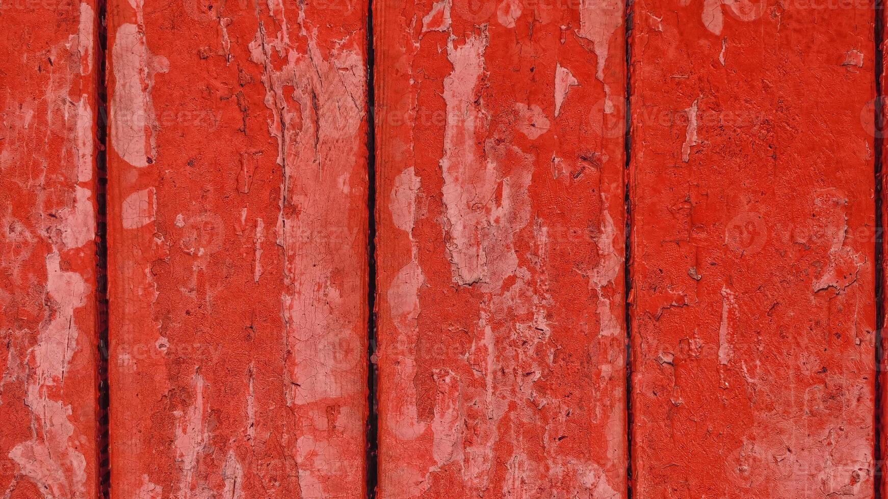 old wooden boards with red peeling paint with cracks. rough surface texture. photo