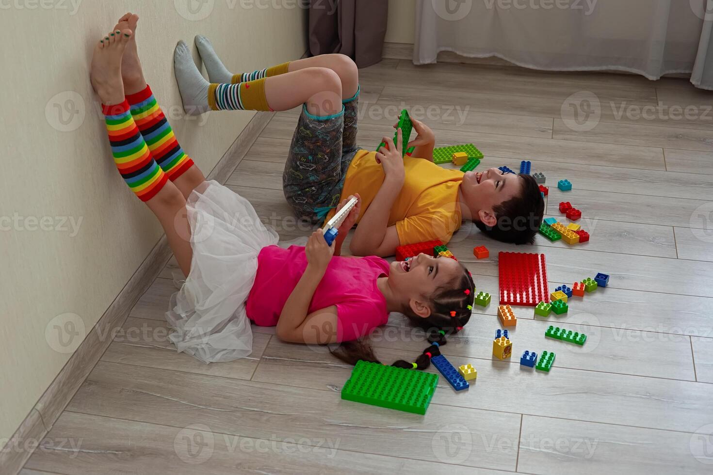 A happy boy and a little girl, lie on the floor photo