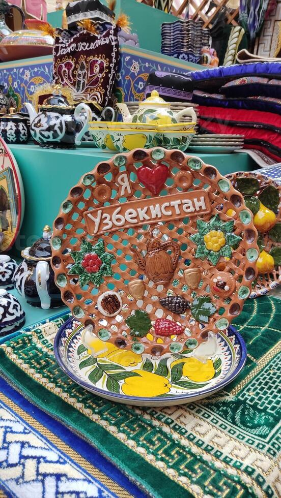 Uzbek ceramic plates and decorative items with an inscription in Russian - I love Uzbekistan. photo