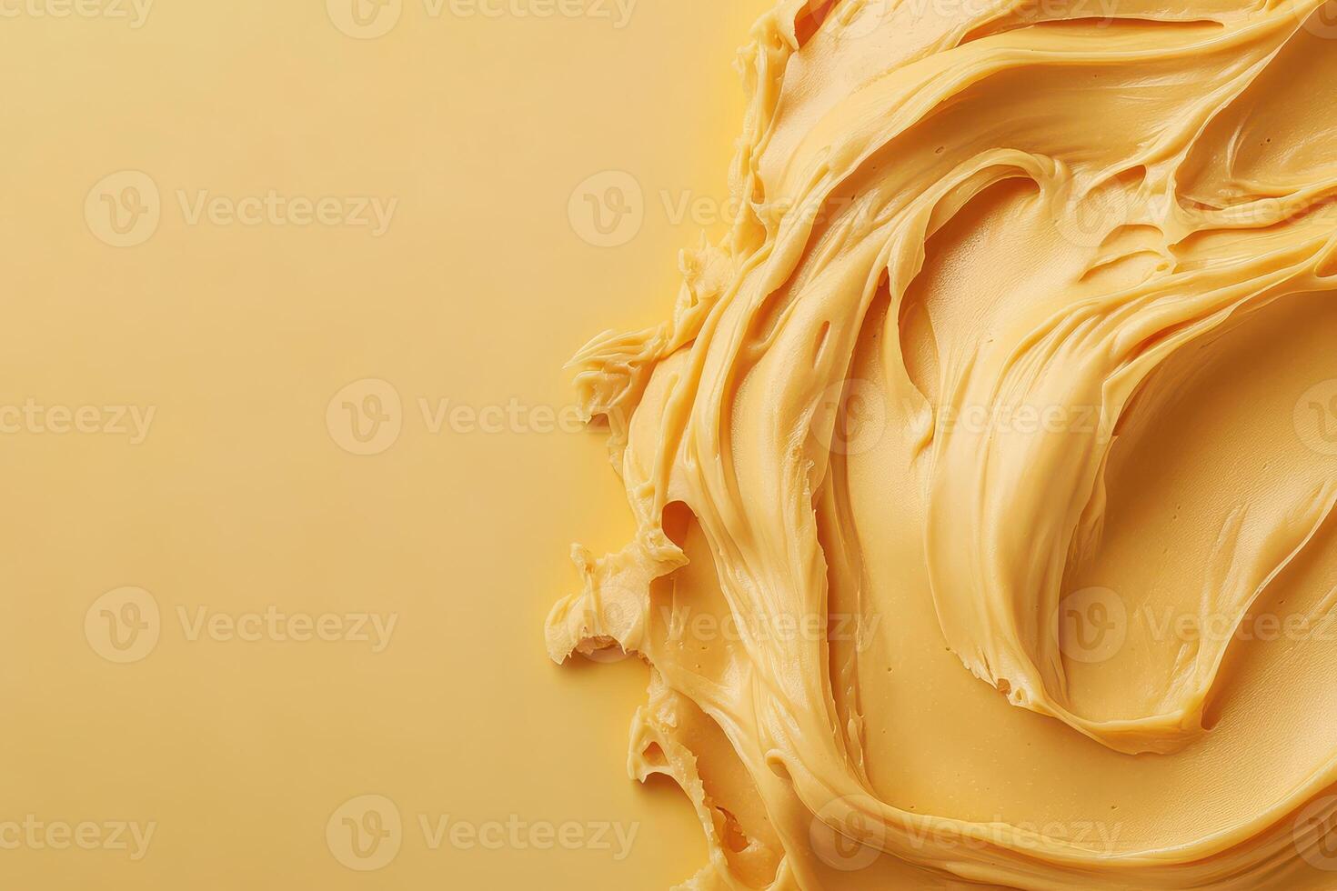 Swirling creamy peanut butter on a warm yellow background photo