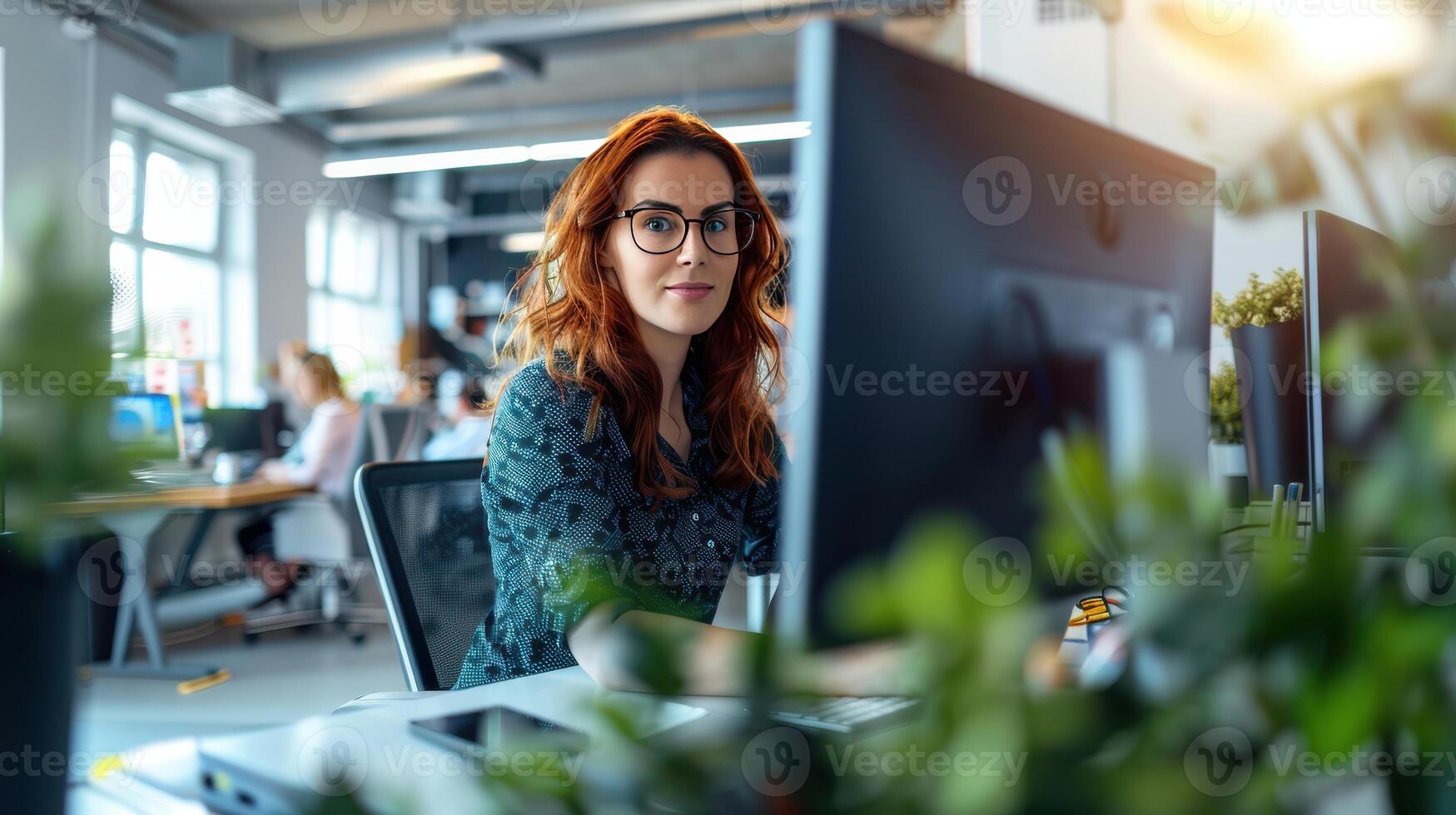 A Day in the Life Focused Redhead Working at a Modern Office Desk photo
