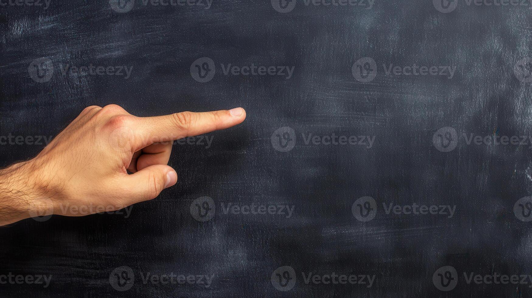 Educator pointing at a blank blackboard with a symbolic gesture. photo
