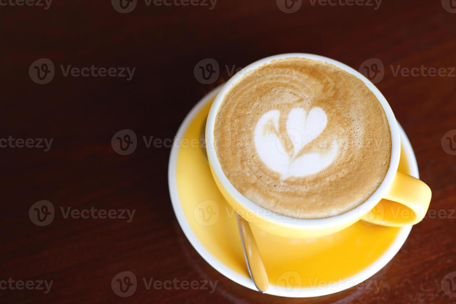 hot coffee cup latte art with spoon Serve ready to drink in cafe on wooden table coffee shop. Leave copy space empty to write the side text. soft focus. photo