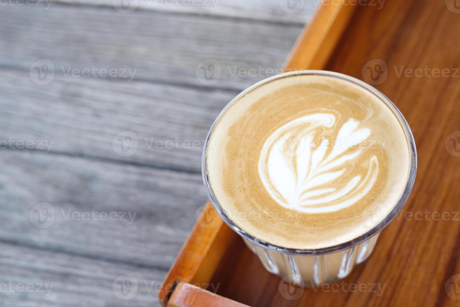 hot coffee cup latte art with spoon Serve ready to drink in cafe on wooden table coffee shop. Leave copy space empty to write the side text. soft focus. photo