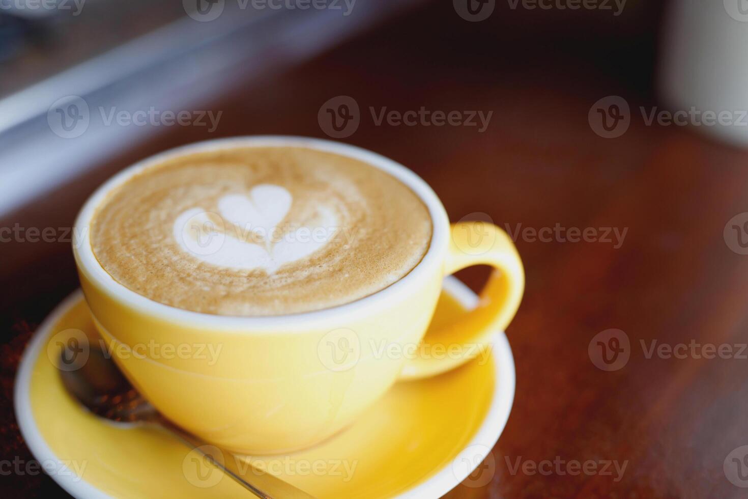 hot coffee cup latte art with spoon Serve ready to drink in cafe on wooden table coffee shop. Leave copy space empty to write the side text. soft focus. photo