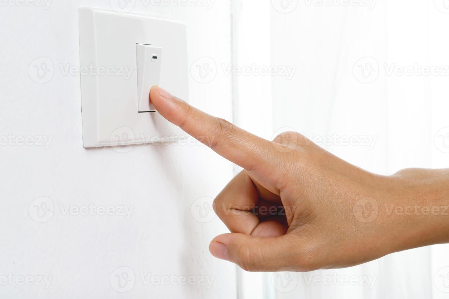 Turn off the light, close up female hand is closing the power switch. Save energy, reduce global warming. photo