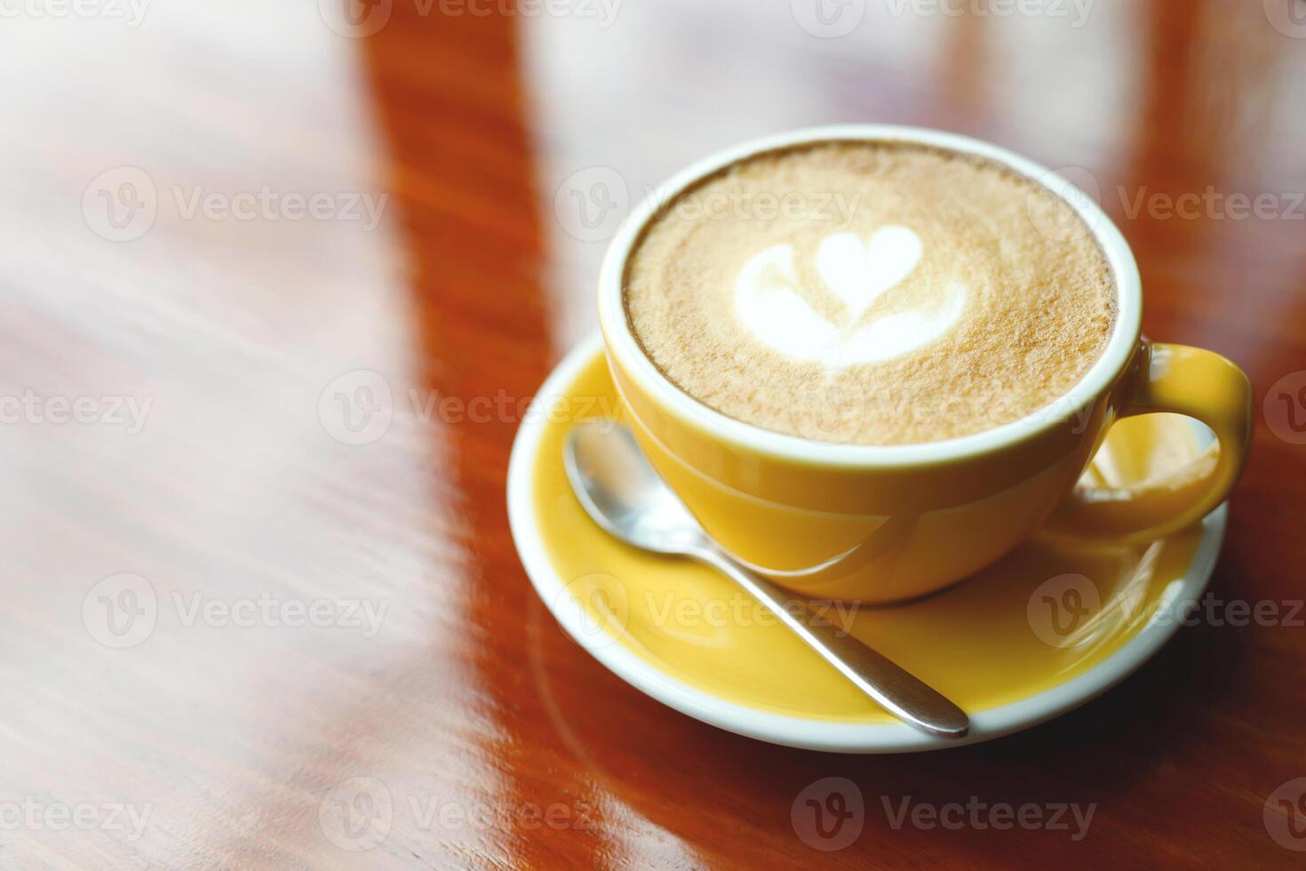 hot coffee cup latte art with spoon Serve ready to drink in cafe on wooden table coffee shop. Leave copy space empty to write the side text. soft focus. photo