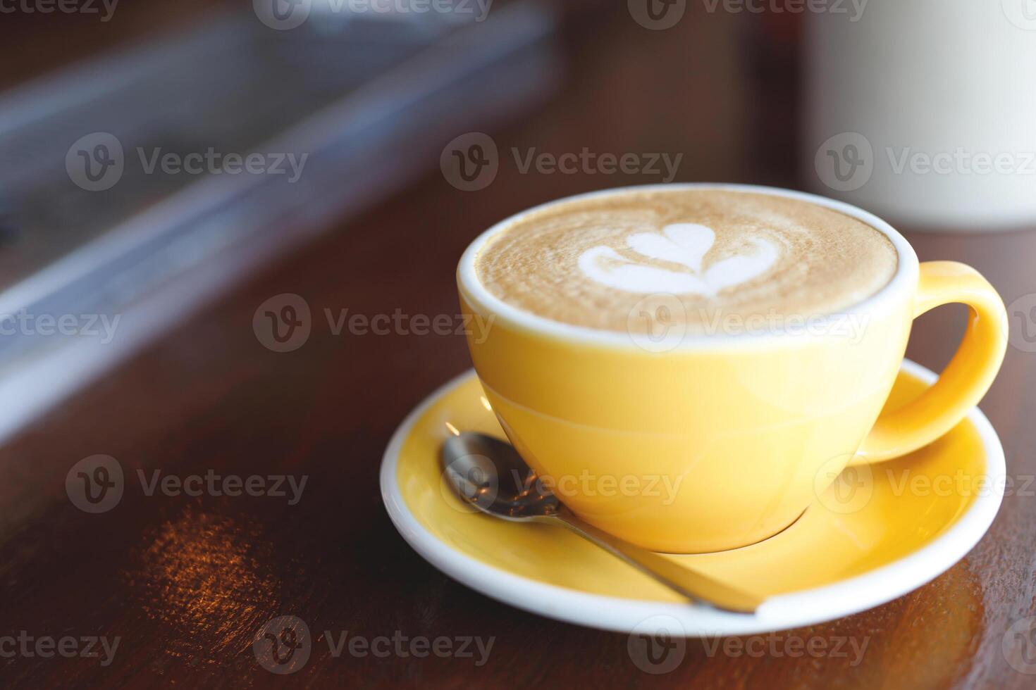 hot coffee cup latte art with spoon Serve ready to drink in cafe on wooden table coffee shop. Leave copy space empty to write the side text. soft focus. photo