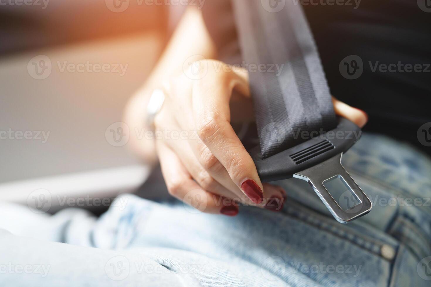 Close Up of people businesswoman hand fastening seat safety belt in car for safety before driving on the road. concept transport travel. soft focus. photo