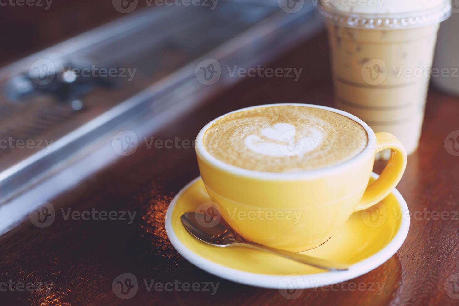 hot coffee cup latte art with spoon Serve ready to drink in cafe on wooden table coffee shop. Leave copy space empty to write the side text. soft focus. photo
