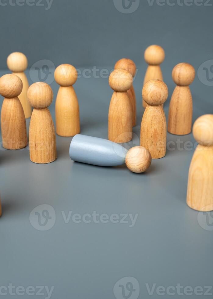 The crowd of people parted around the fainted gray man, the figurine. The concept of depression, mental and psychological problems. Burnout at work, loss of strength. photo