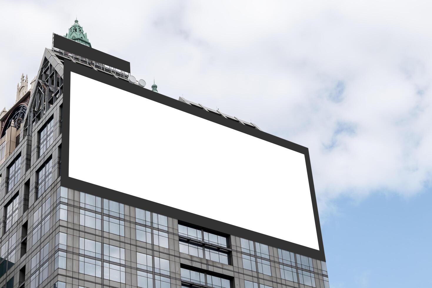 Mock up white LED display billboard on tower building with blue sky background .clipping path for mockup photo