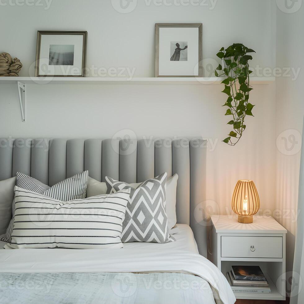 Bedroom with plush headboard, pillows, and a shelf with plant and pictures For Social Media Post Size photo