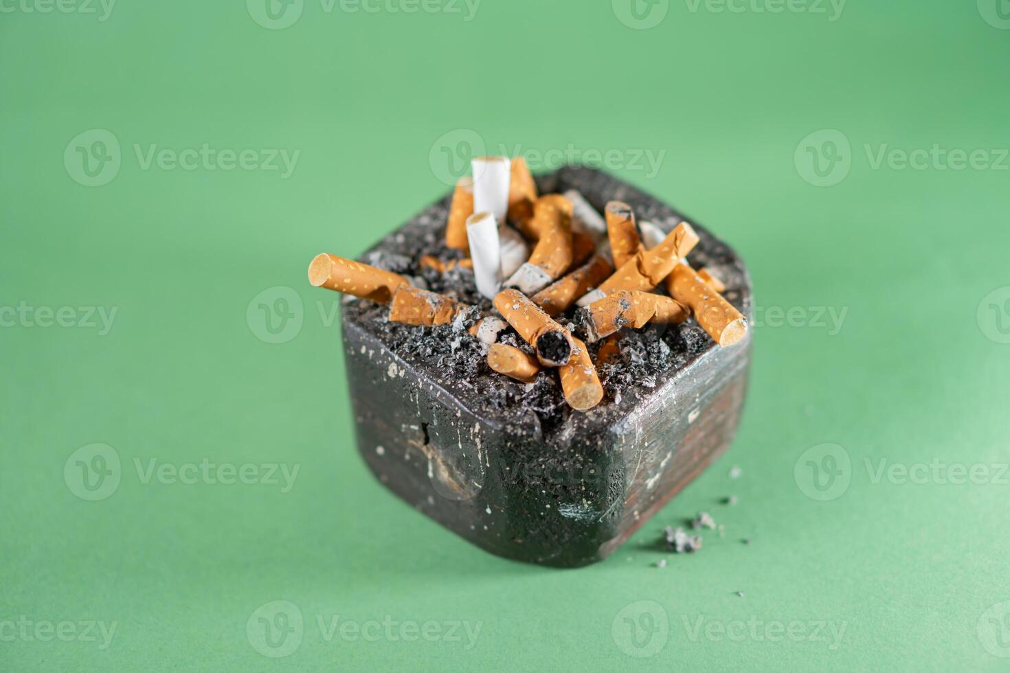 A cigarette in a black box with a green background photo