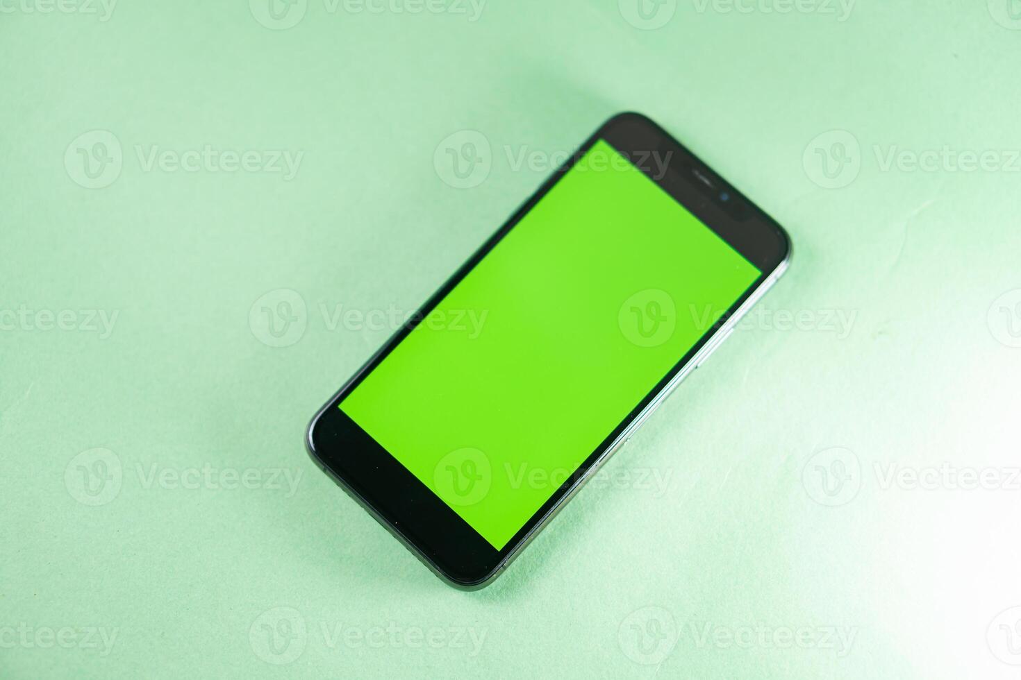 Smart phone with Green Screen on Light Background photo