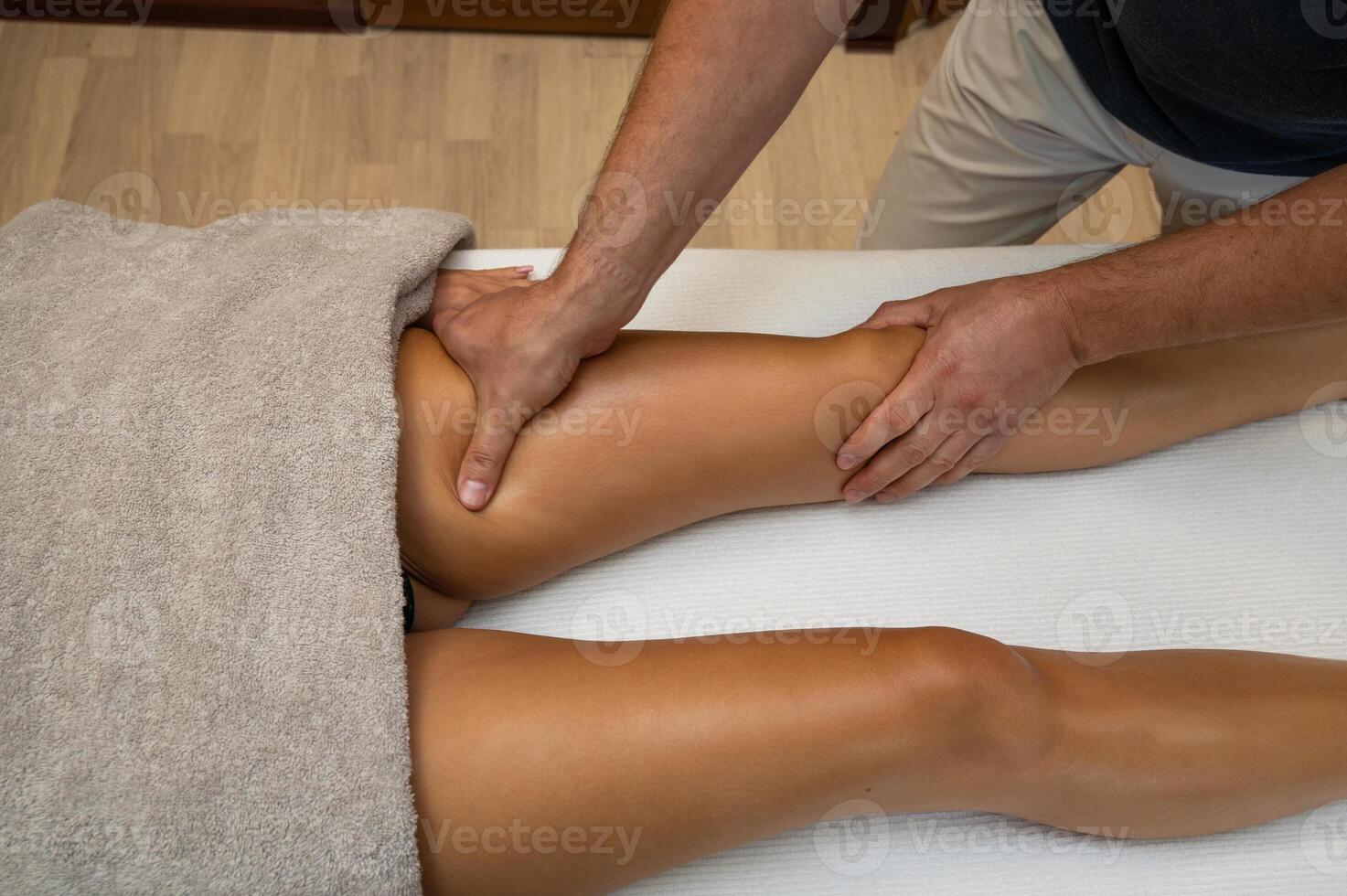Woman getting legs massage in spa salon photo