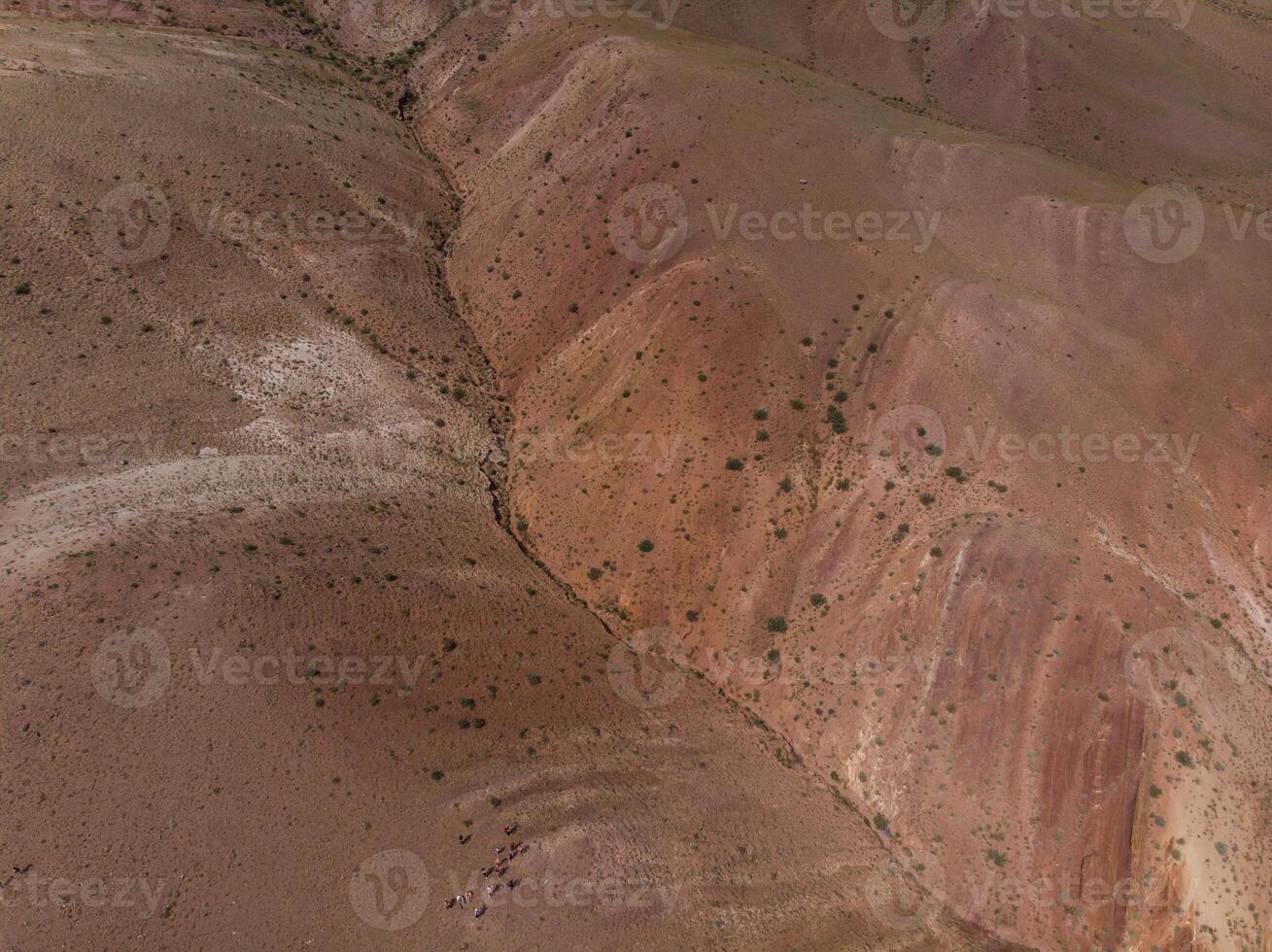Aerial shot of the textured yellow nad red mountains resembling the surface of Mars photo