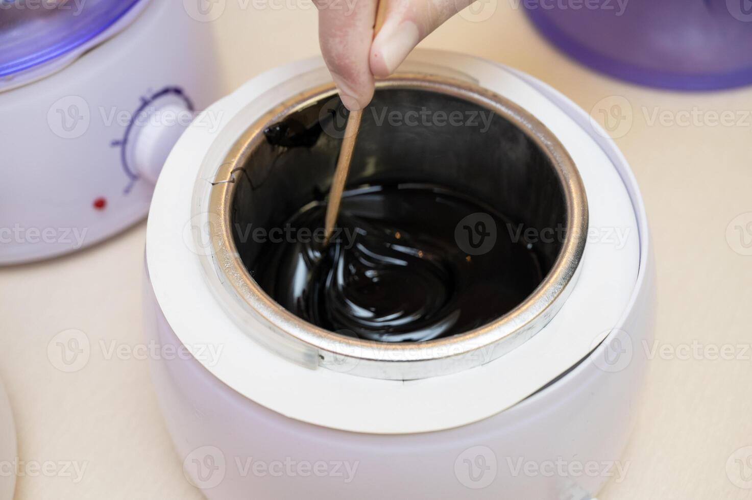 Cosmetologist in beauty clinic preparing white shugaring paste photo