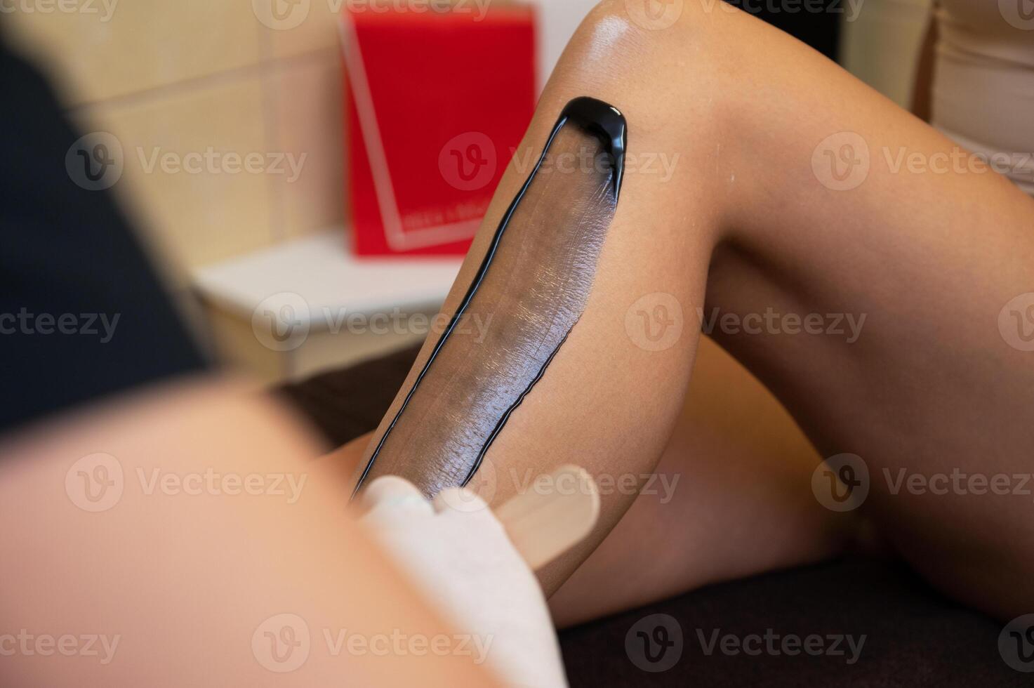 Woman legs closeup in beauty clinic ready for removing hair procedure photo