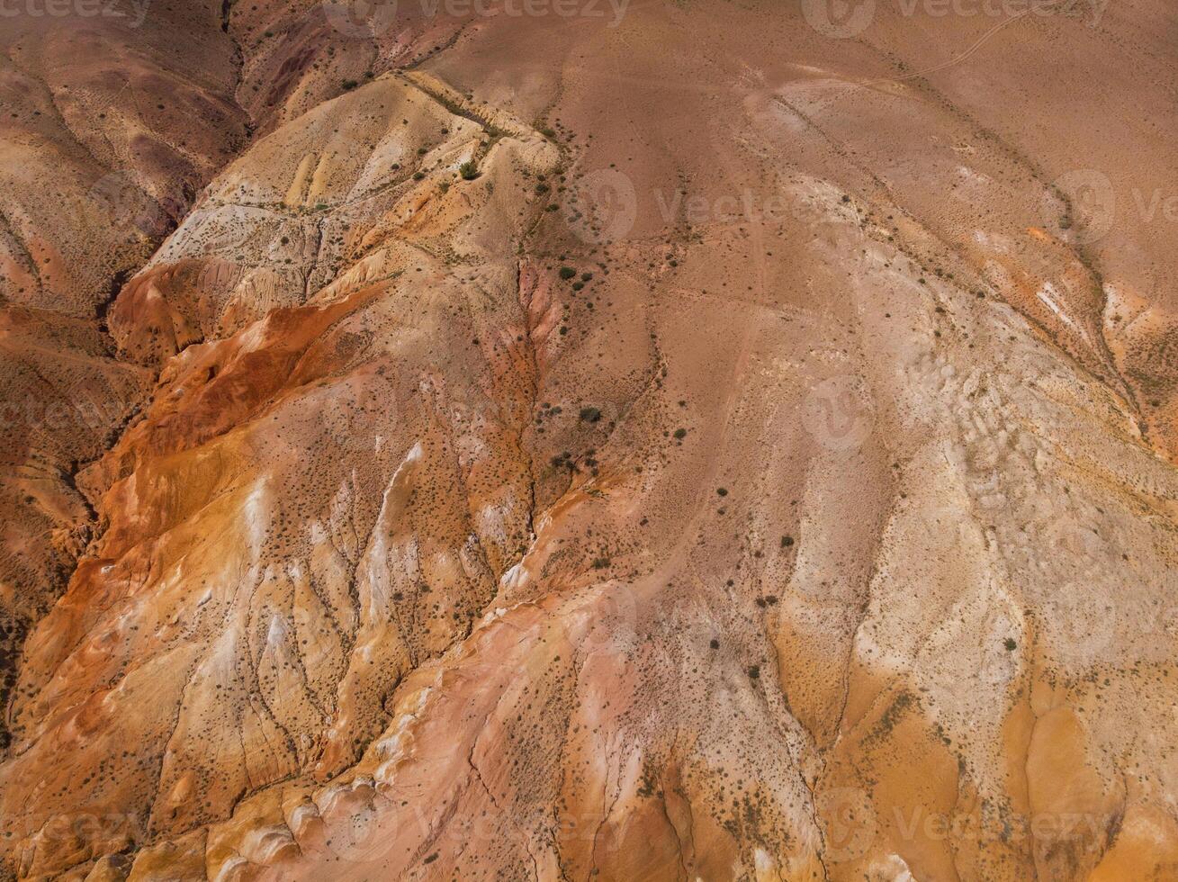 Aerial shot of the textured yellow nad red mountains resembling the surface of Mars photo