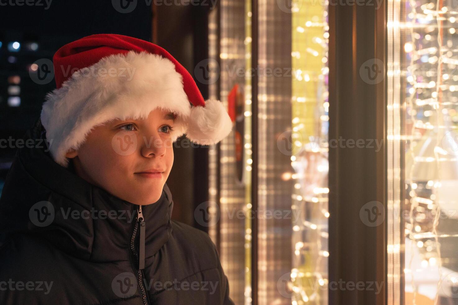 Boy in Santas hat looking in shop window photo