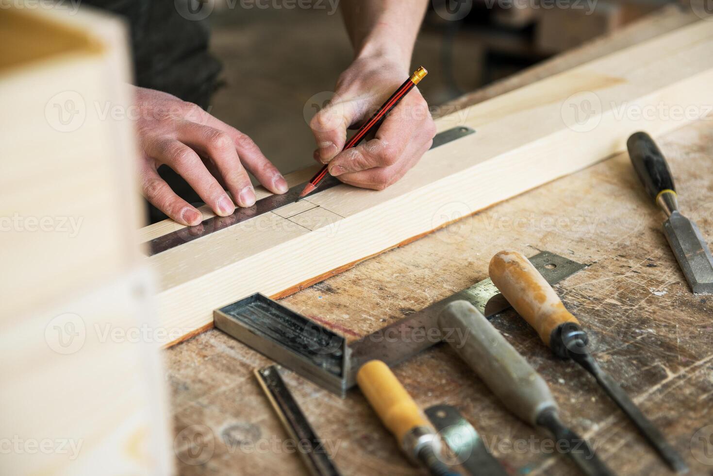 The worker makes measurements of a wooden board photo