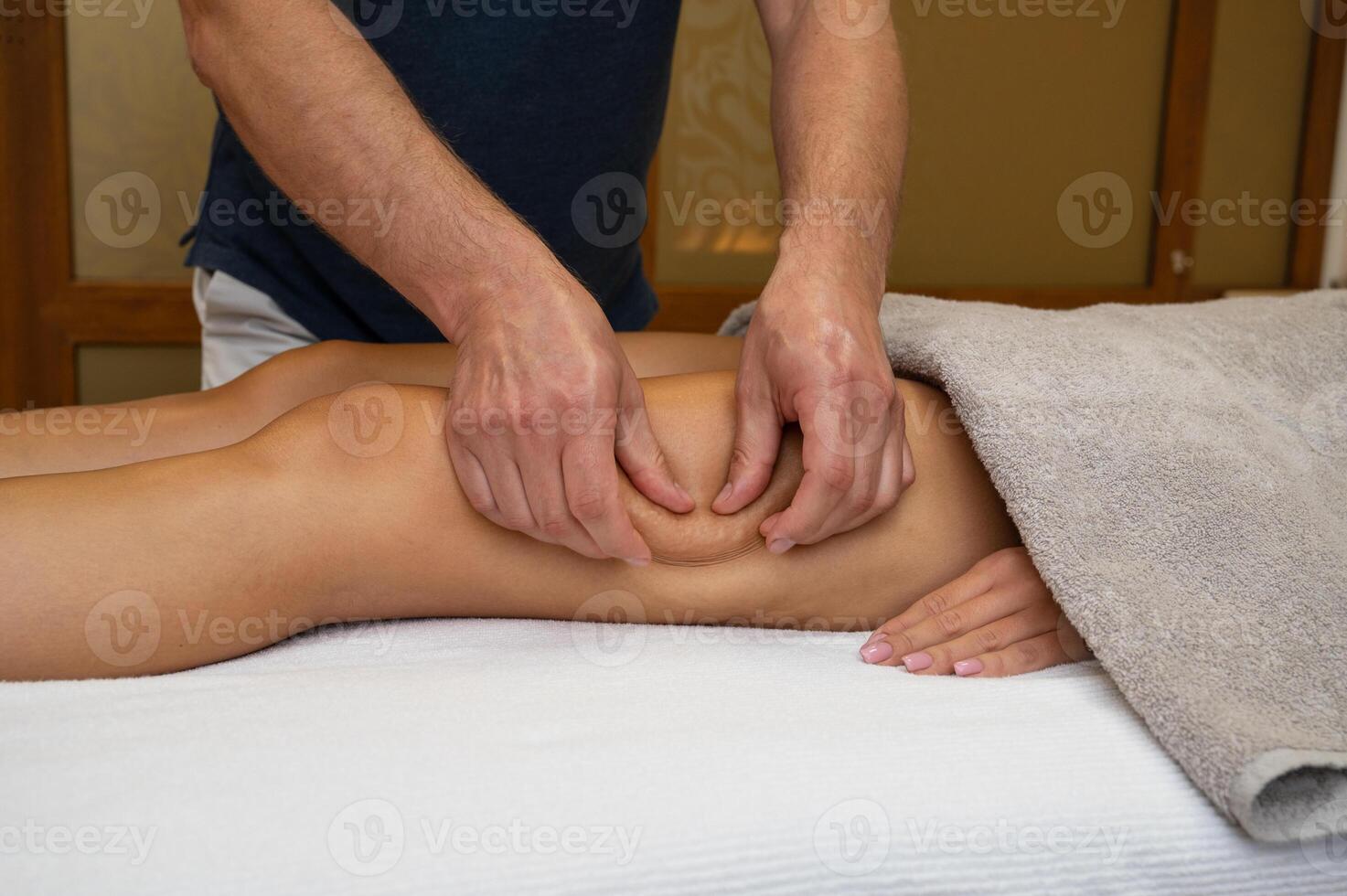 Woman getting legs massage in spa salon photo