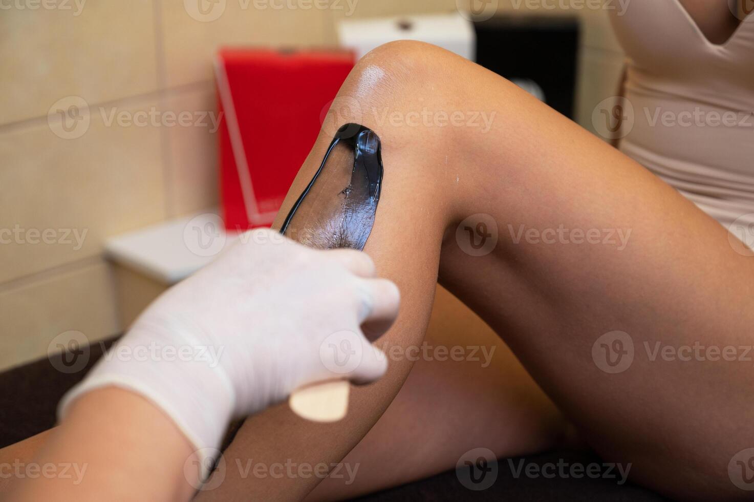 Cosmetologist in beauty clinic performs a epilation procedure photo