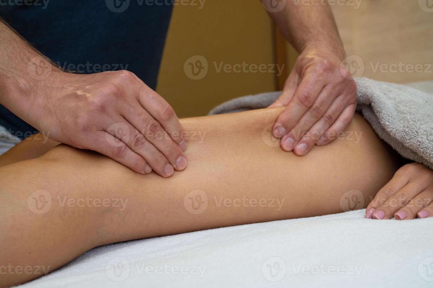 Woman getting legs massage in spa salon photo