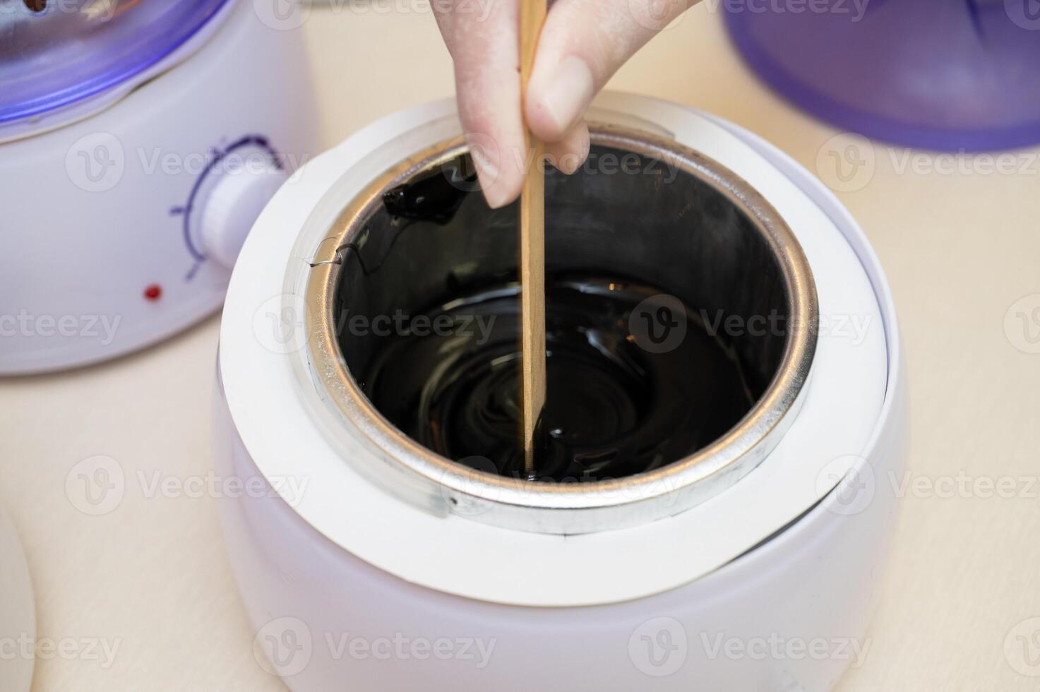 Cosmetologist in beauty clinic preparing white shugaring paste photo