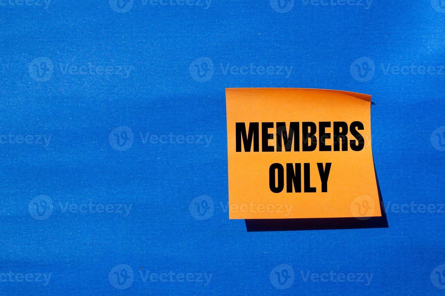 Members only message written on orange paper with blue background. Conceptual members only symbol. Copy space. photo