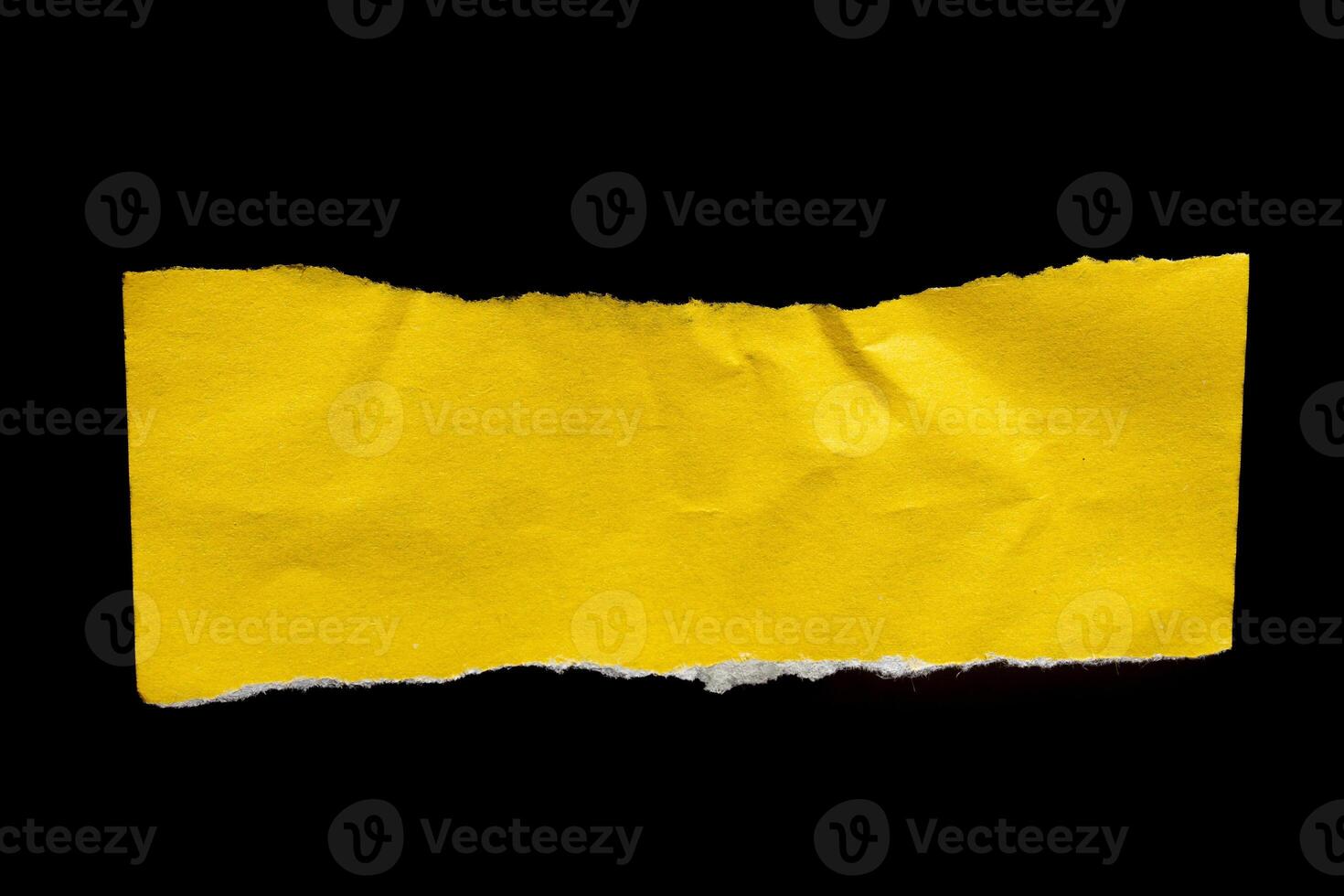 Yellow paper torn piece of paper on black background photo