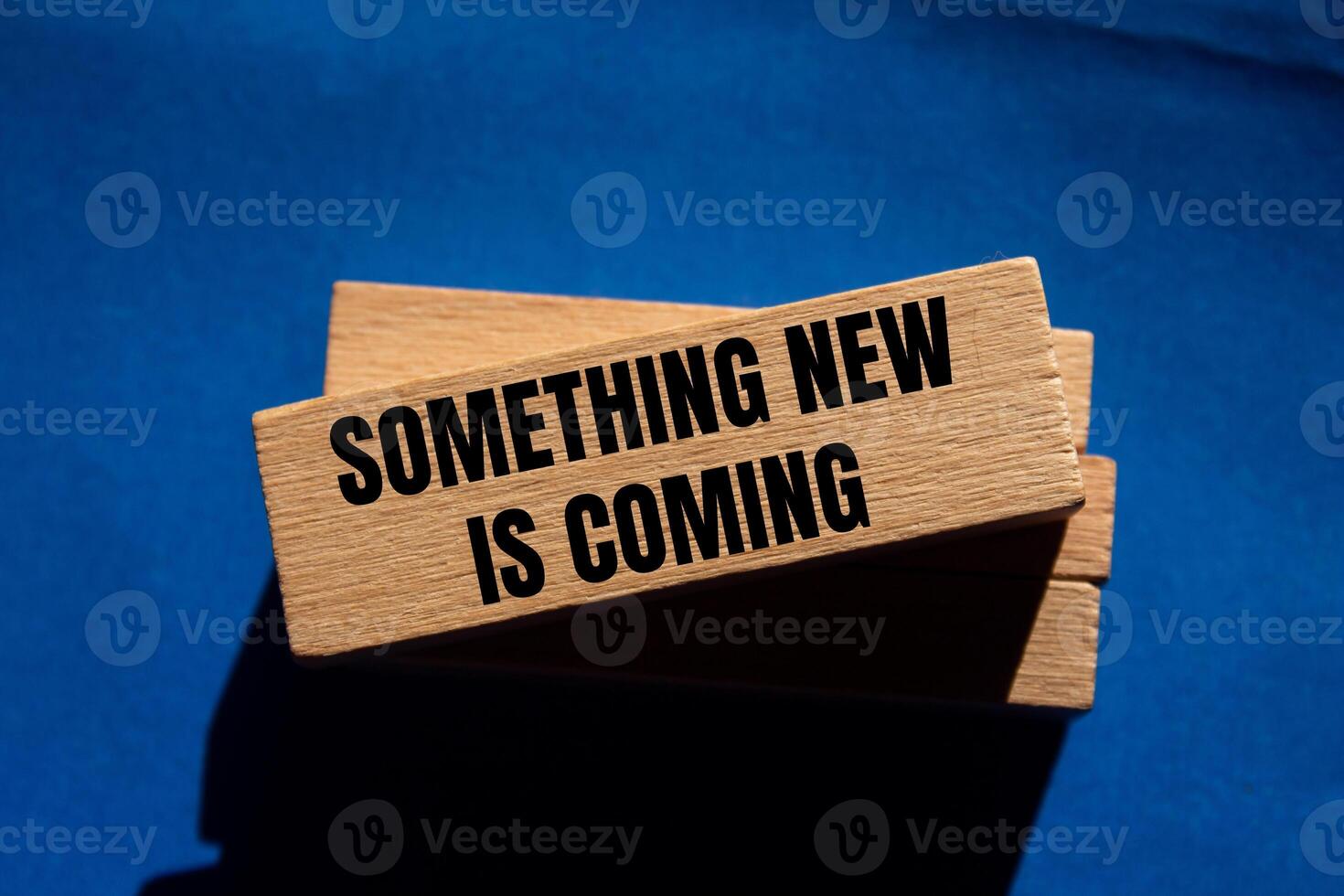 Something new is coming message written on wooden blocks on blue background. Conceptual something new is coming symbol. Copy space. photo