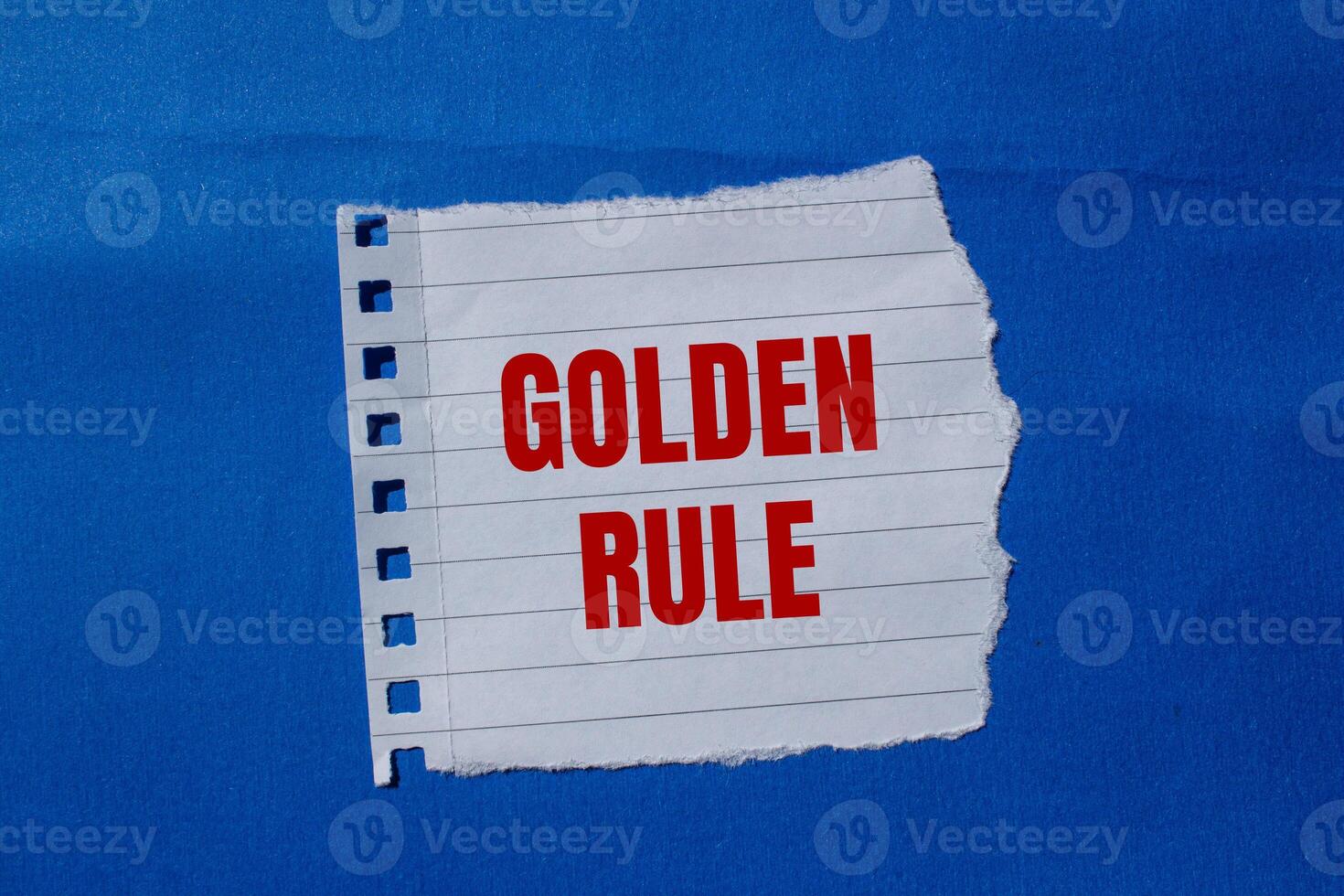 Golden rule text on a piece of paper on a blue background photo
