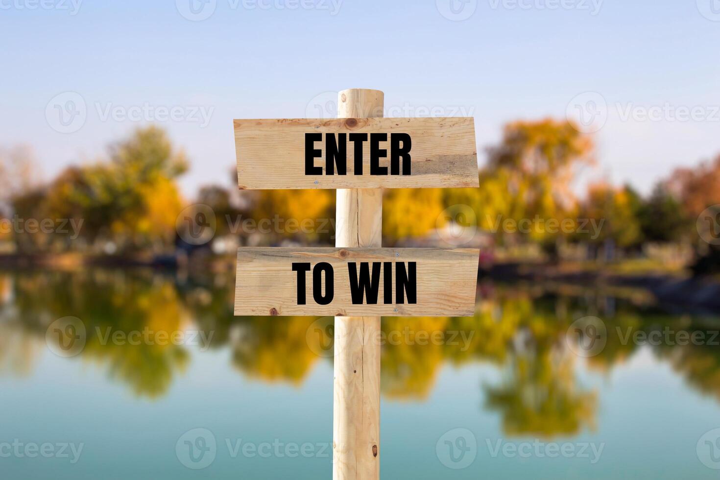 Enter to win message written on wooden sign with blurry nature background. Conceptual enter to win symbol. Copy space. photo
