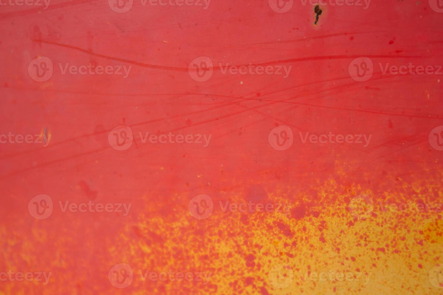 A skateboarder is riding a red and yellow board photo