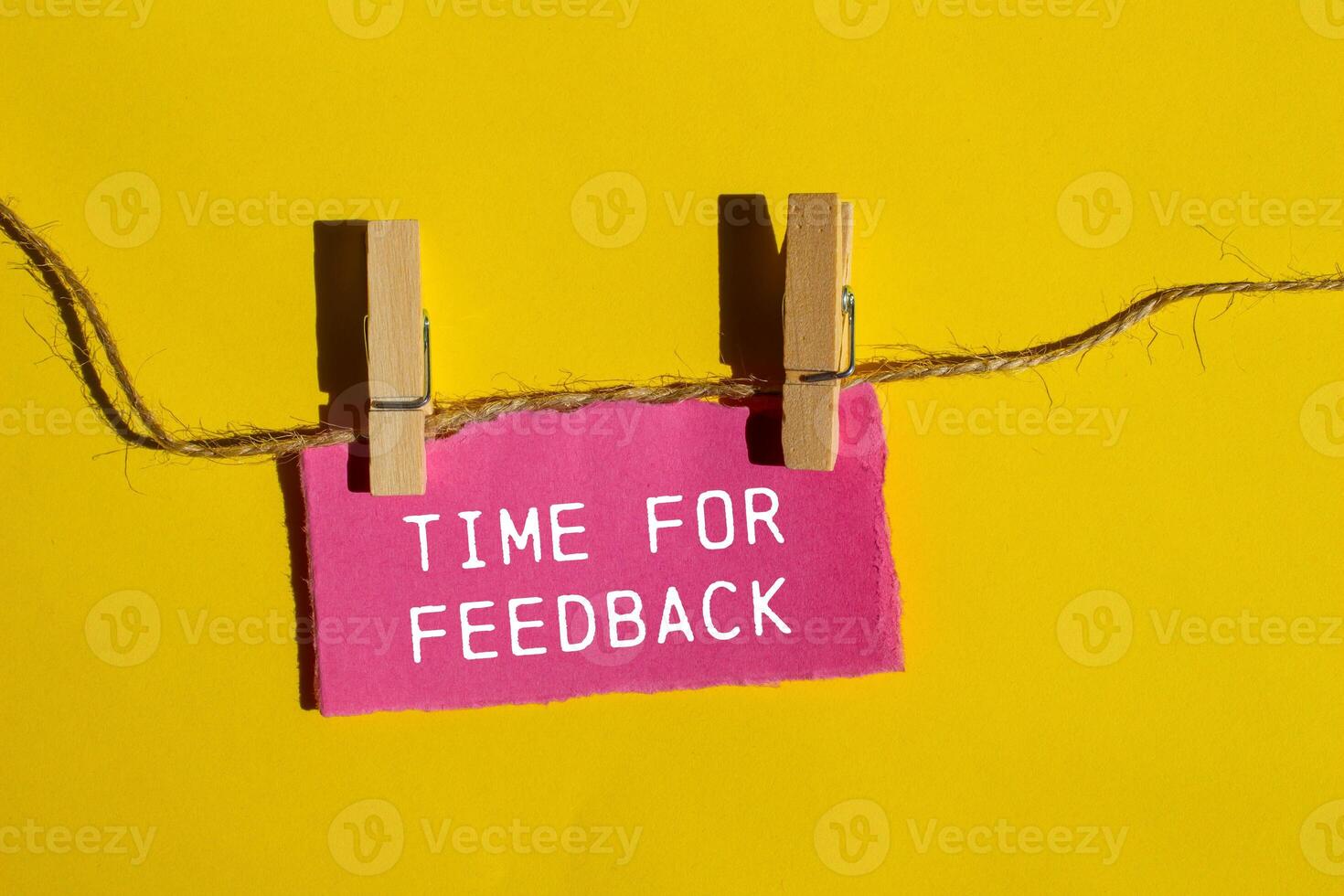Time for feedback words written on ripped pink paper piece with yellow background. Conceptual time for feedback symbol. Copy space. photo