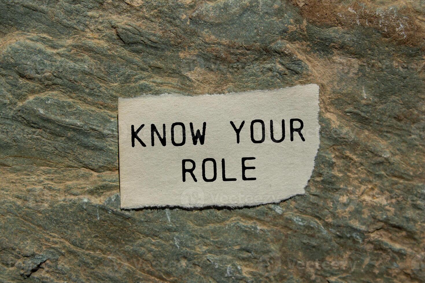Know your role message written on ripped torn paper piece on stone background. Conceptual know your role symbol. Copy space. photo