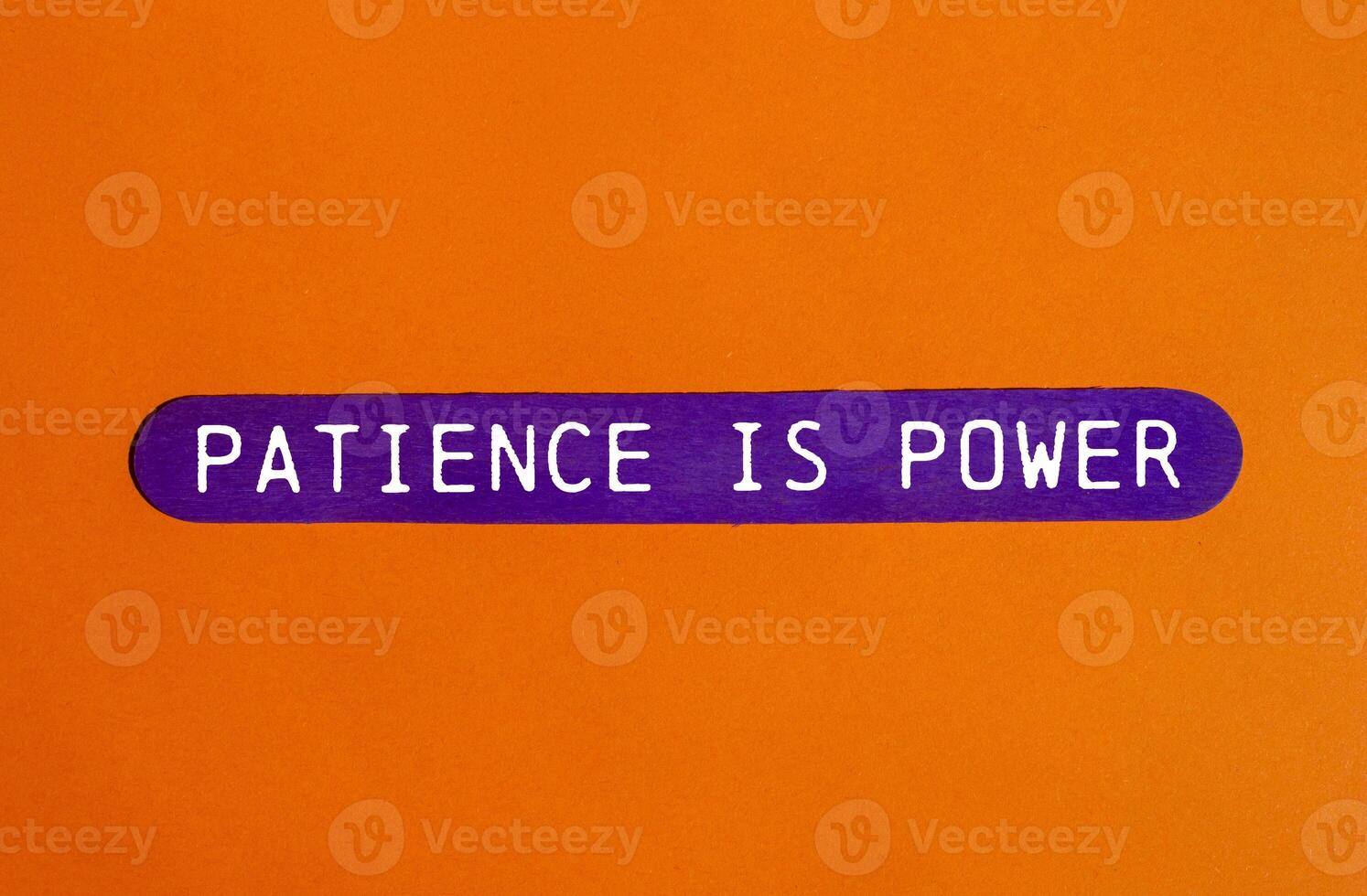 Patience is power message written on purple wooden stick on orange background. Conceptual patience is power symbol. Copy space. photo